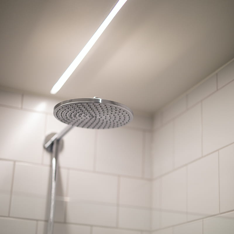 LEDstrip med høj IP klasse placeret over et brusebad i et badeværelse.